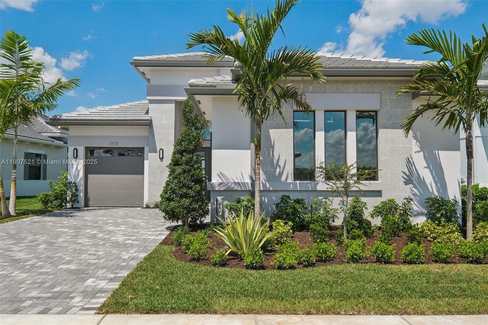 A modern two story home with palm trees